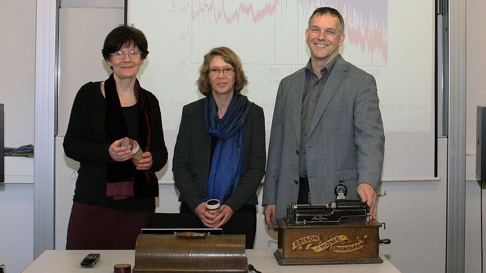 Foto: Auf der Suche nach dem historischen Klang der Stimme: Prof. Dr. Rebecca Grotjahn, Dr. Karin Martensen und Prof. Dr.-Ing. Malte Kob vor einer akustischen Klanganalyse eines Edison-Phonographen. © HfM Detmold/Plettenberg